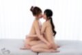 Girls kneeling on couch kissing nude